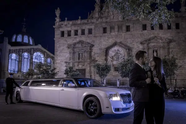 Pareja disfrutando de un paseo nocturno en limusina por el centro de Valencia.