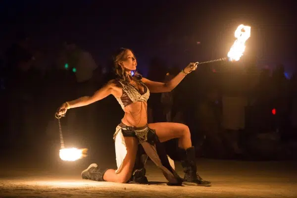Artista realizando un espectáculo de fuego durante un show nocturno en Valencia.