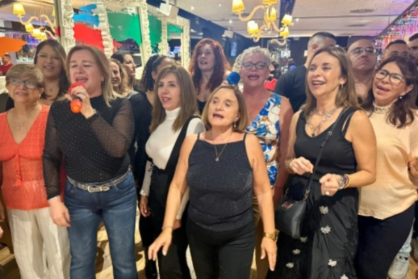 Grupo disfrutando de una cena de empresa en Isla Despedidas Valencia con música y animación