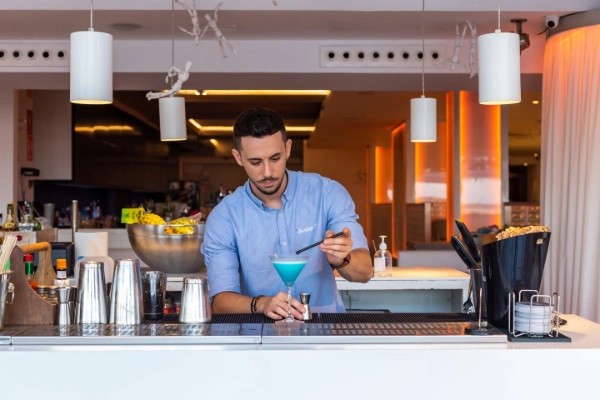 Barman preparando un cóctel en Destino 56, restaurante en primera línea de la Playa de las Arenas en Valencia.