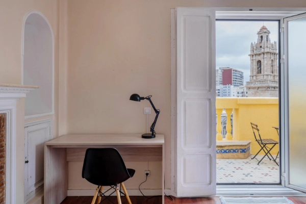 Zona de escritorio con vista a la ciudad, ideal para descansar o trabajar durante tu despedida en Valencia.