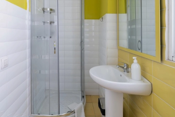 Baño privado con ducha y lavabo, ideal para habitaciones compartidas en despedidas en Valencia.