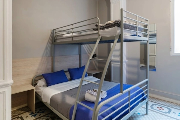 Habitación con litera triple y cama de matrimonio para alojar grupos de despedida en Valencia.