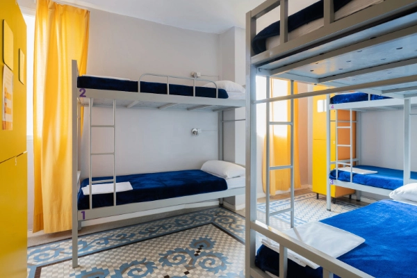 Dormitorio compartido con literas metálicas y espejo grande en alojamiento para despedidas.