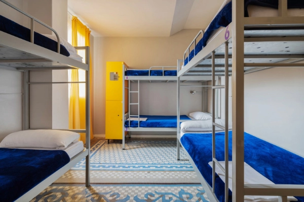 Habitación con literas metálicas y taquillas privadas, ideal para grupos de despedida en Valencia.