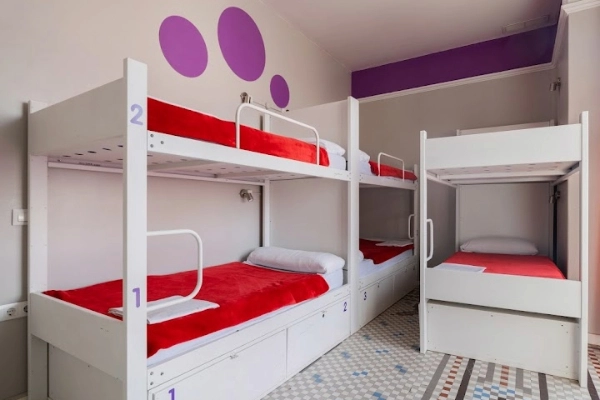 Habitación compartida con literas blancas y decoración moderna, ideal para despedidas de soltera en Valencia.