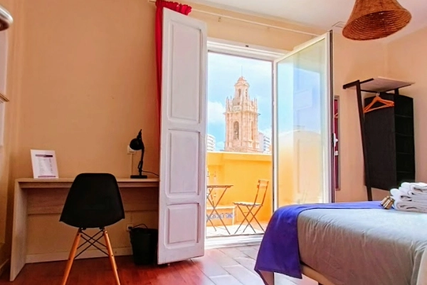 Habitación privada con balcón y vistas al centro histórico de Valencia.