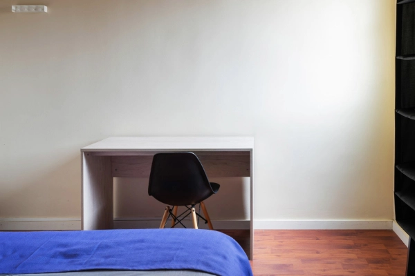 Habitación con cama individual y escritorio, perfecta para descanso o teletrabajo durante despedidas.