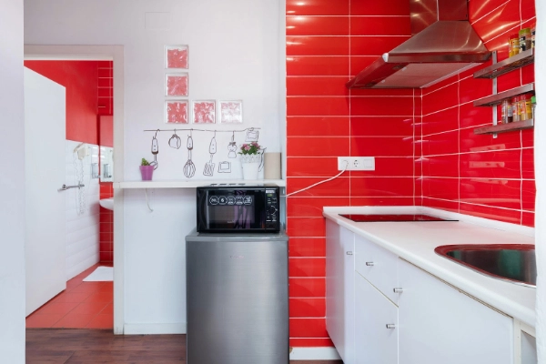 Cocina equipada con microondas, nevera y utensilios, ideal para grupos alojados en despedidas en Valencia.
