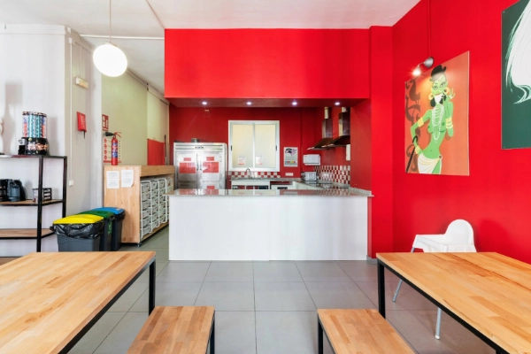 Vista frontal de la cocina del hostel con encimeras blancas y azulejos decorativos.