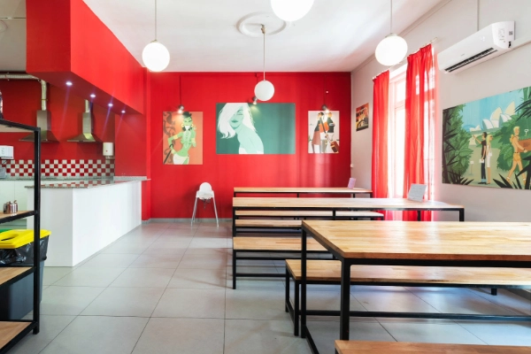 Comedor amplio con mesas compartidas en el Red Nest Hostel, ideal para grupos y despedidas.