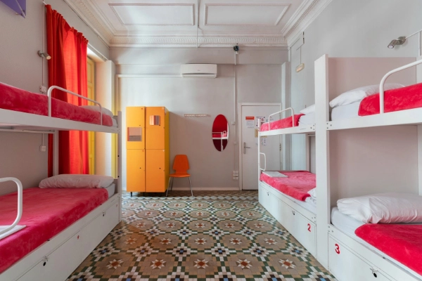 Habitación compartida con literas, taquillas de seguridad y espejo en el Red Nest Hostel.