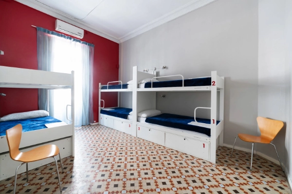 Habitación compartida con literas y suelo de mosaico tradicional en el centro de Valencia.