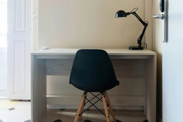 Escritorio individual con lámpara en habitación del Red Nest Hostel, ideal para leer o trabajar.