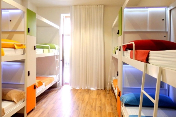 Habitación compartida con literas coloridas y luz natural en el Hostel Urban Youth.