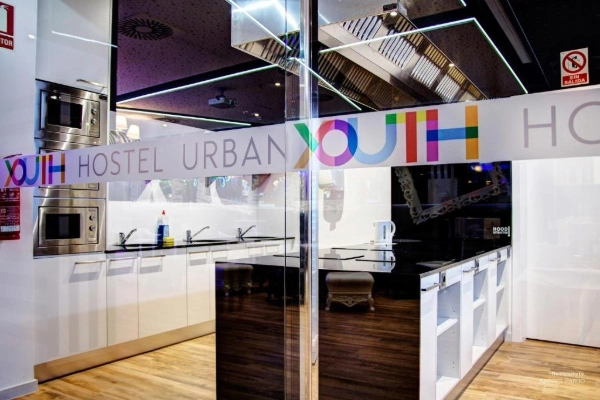 Entrada a la cocina del Hostel Urban Youth con el logotipo en cristal.