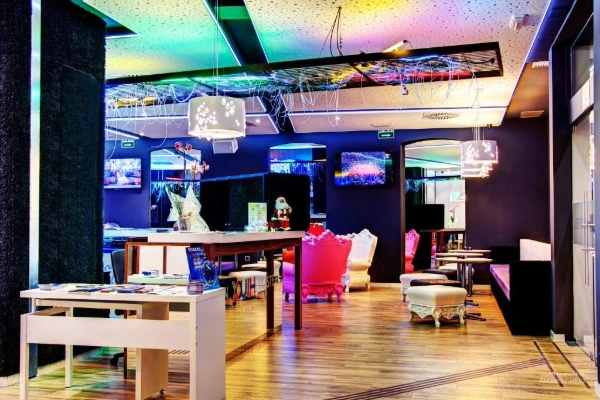 Zona común moderna con luces LED y pantallas en el Hostel Urban Youth de Valencia.