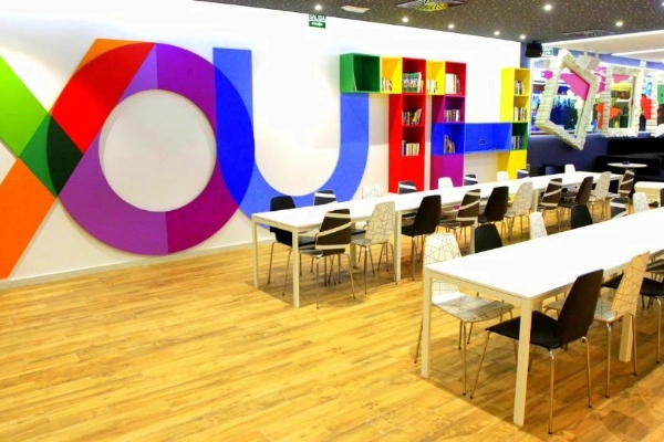 Comedor moderno con decoración tipográfica y estanterías en el Hostel Urban Youth.