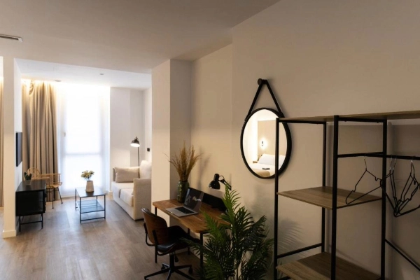 Apartamento Alma Demetrio con escritorio, decoración moderna y cama al fondo.
