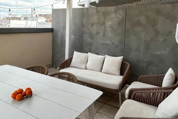 Terraza privada con sofá y mesa exterior en Alma Demetrio Valencia.