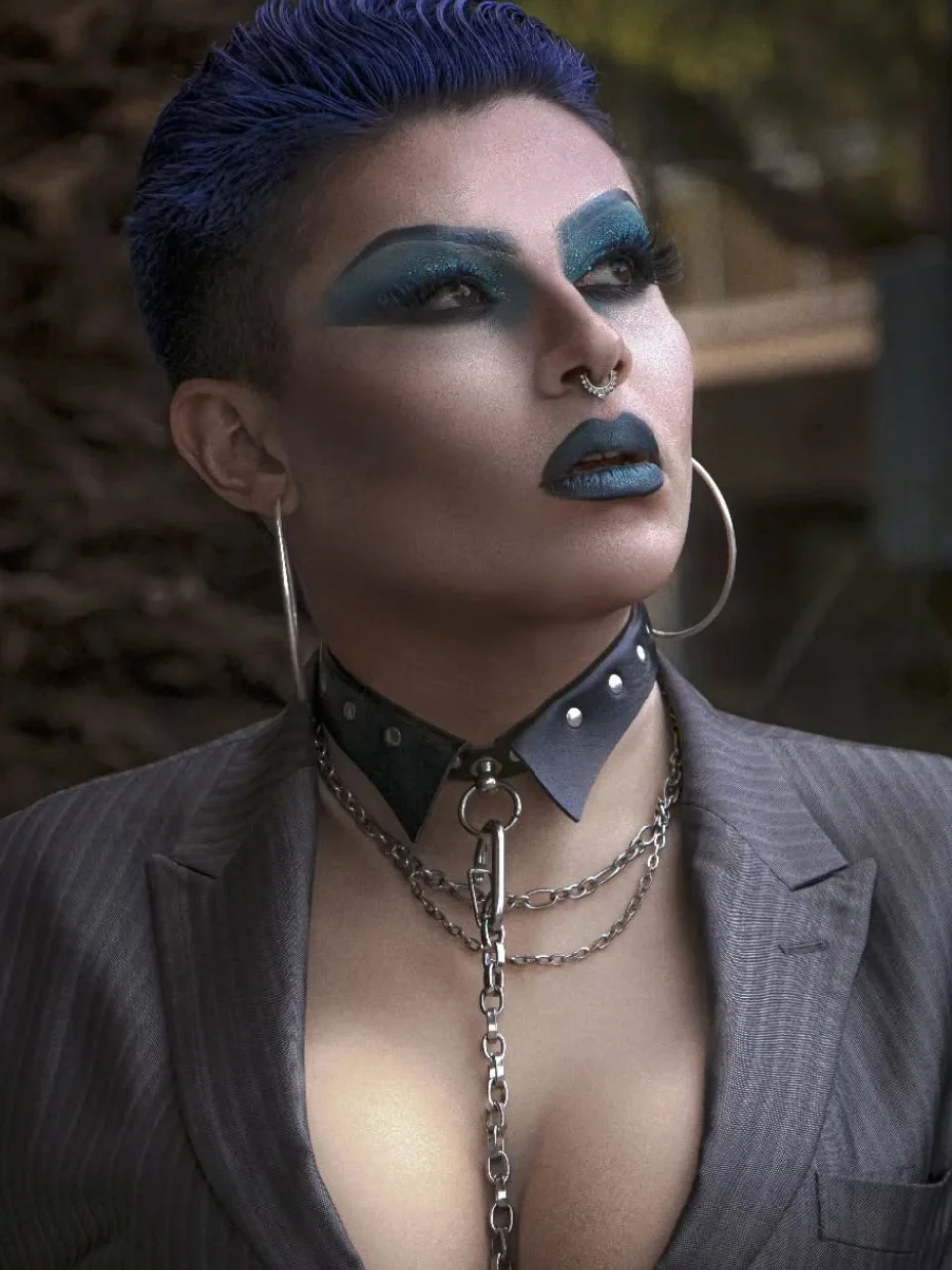 Retrato de drag queen conceptual con maquillaje azul intenso, peinado corto y estilismo urbano en Valencia.