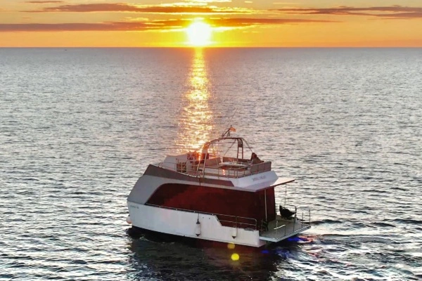Catamarán Cocoon de alquiler en Valencia para grupos de hasta 10 personas navegando al atardecer
