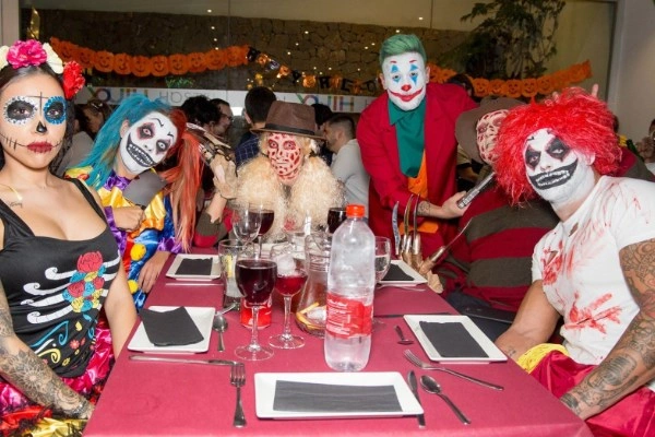 Grupo de personas disfrazadas cenando en una cena temática de Halloween en Valencia