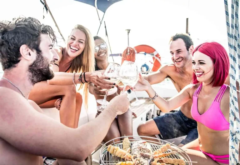Grupo de jóvenes brindando en una fiesta en barco en Valencia al atardecer