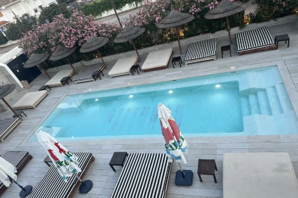 Piscina de beach club en Valencia con camas balinesas y sombrillas
