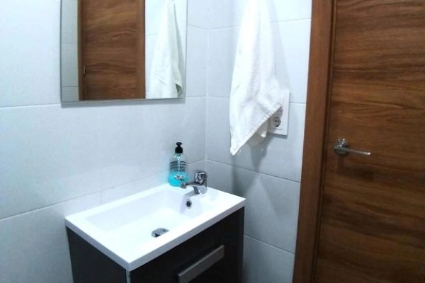Baño moderno con lavabo y espejo en hostal del Puerto de Valencia