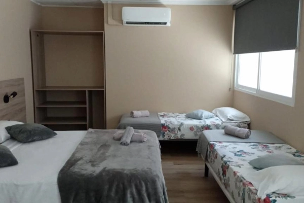 Habitación con varias camas en hostal cerca de la playa de Valencia