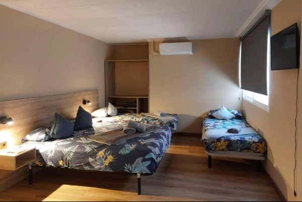 Habitación con cama doble y cama individual en hostal cerca de la playa de Valencia