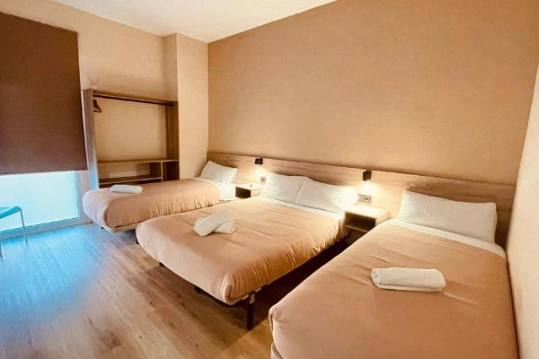 Habitación triple con cama doble y cama individual en hostal del Puerto de Valencia