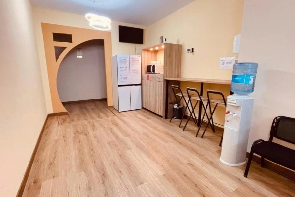 Espacio común con cocina equipada y barra en hostal cerca de la playa de Valencia