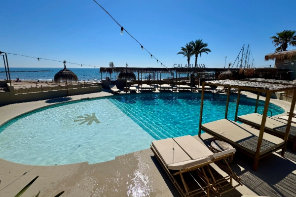 Beach club con piscina y camas balinesas frente al mar en La Pobla de Farnals Valencia